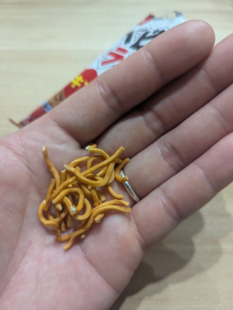 Baby Star Ramen crispy noodle pieces held in palm close-up
