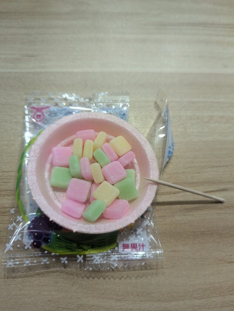 Fruits no Mori dagashi opened showing colorful candies in monaka wafer bowl with toothpick