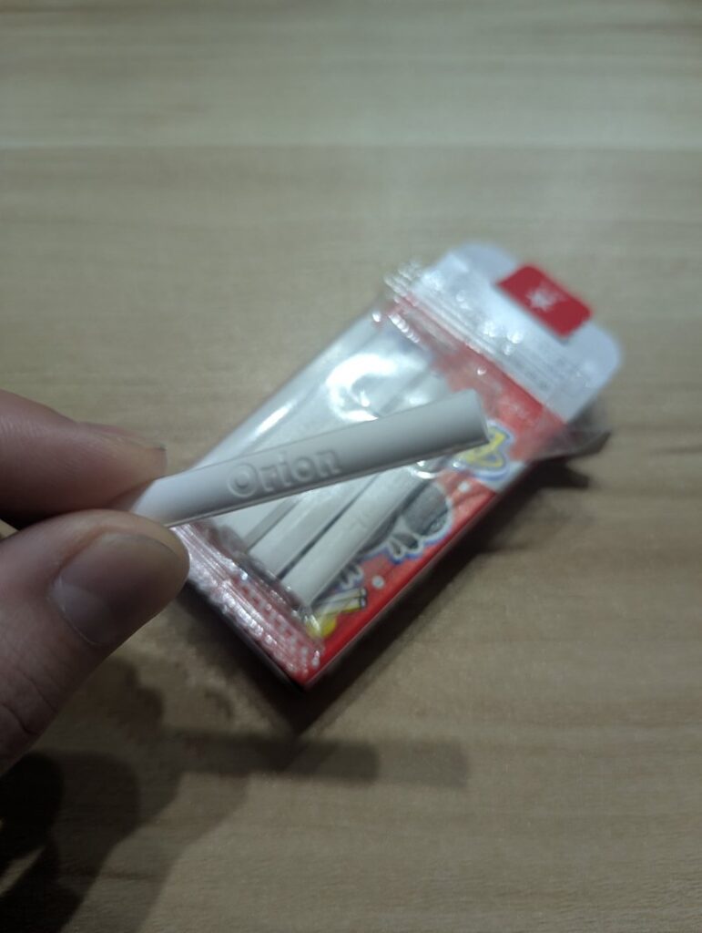 Close-up of one Cola Cigarette ramune candy stick showing Orion logo