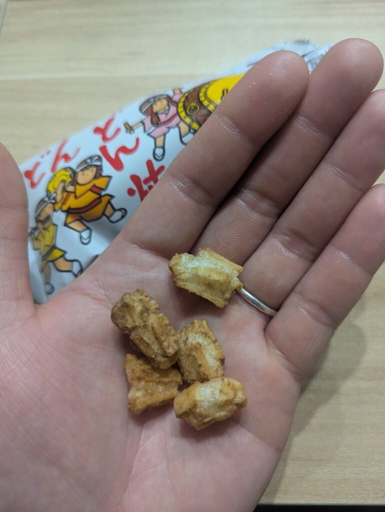 Handful of Dondon Yaki crispy snack pieces held in hand