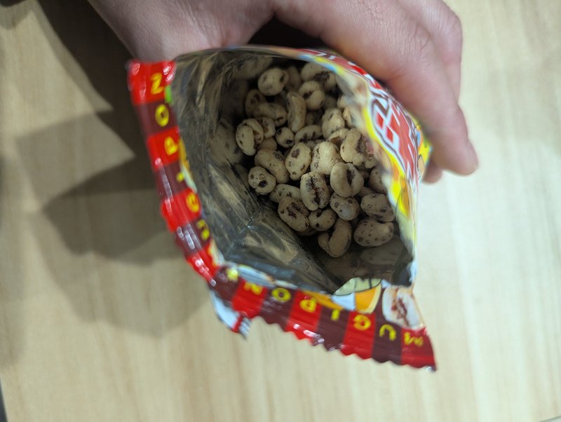 Top view of open Mugipon bag filled with puffed wheat snacks