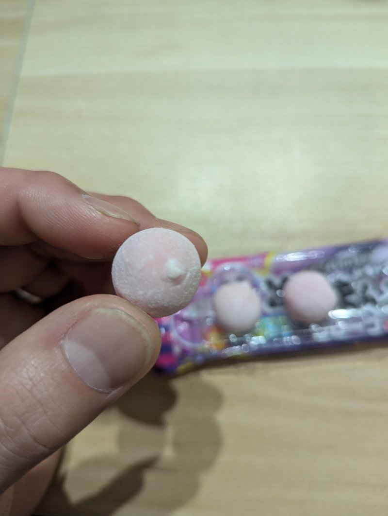 Holding one piece of Sono Mama Grape gum before eating