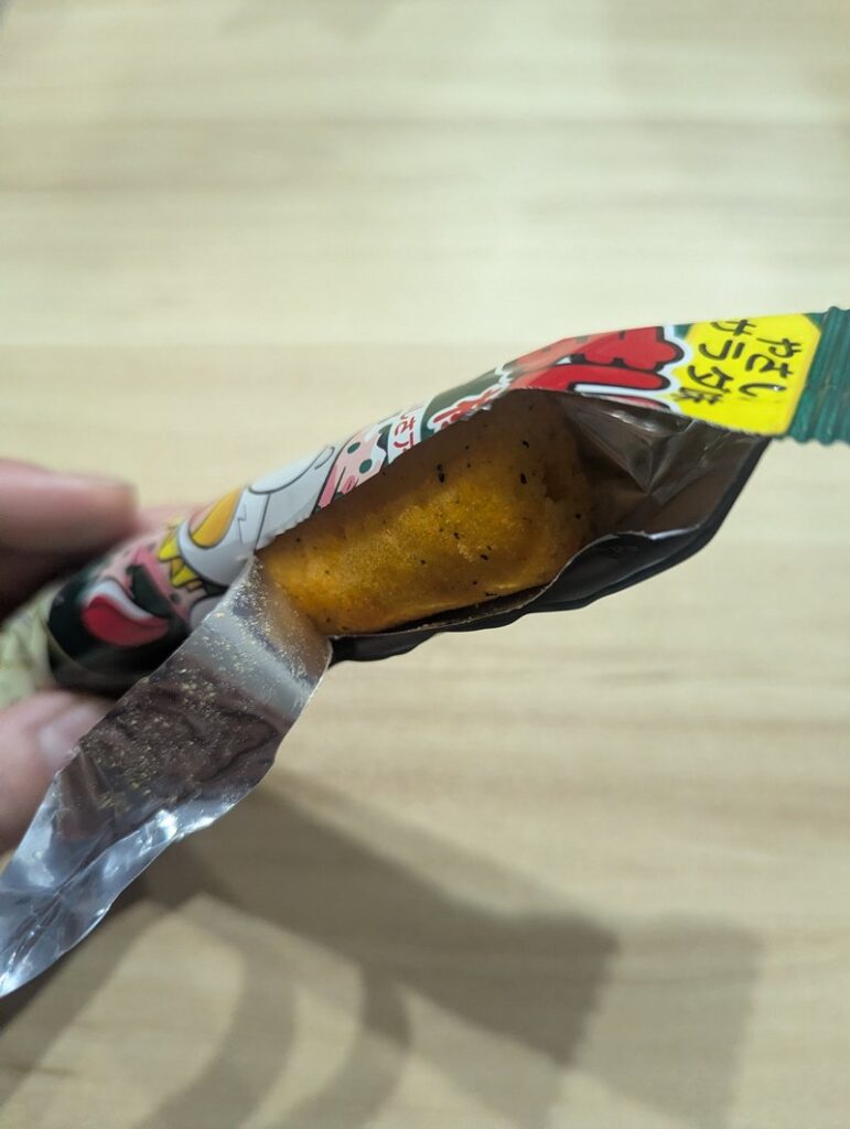 Opening Umaibo Yasai Salad flavor package showing the corn puff inside