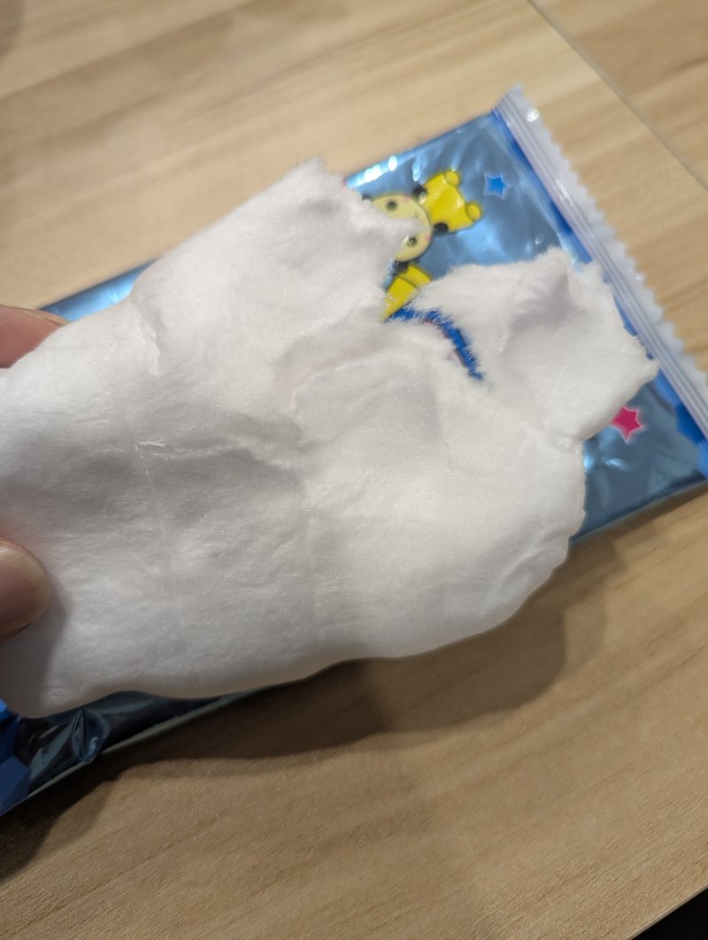Holding a large piece of watagashi Japanese festival cotton candy